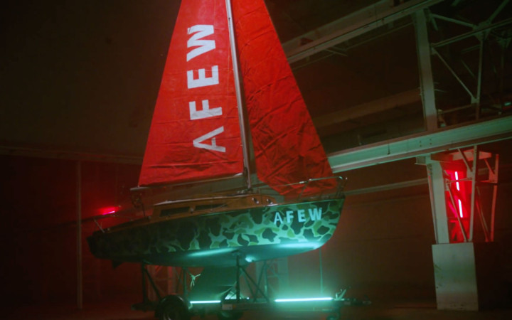 Segelschiff mit Logo von AFEW in rot-grünem Licht.