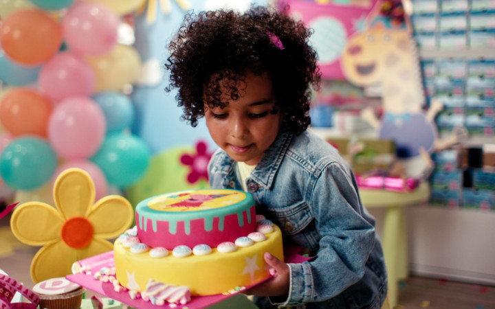 Ein Mädchen mit Torte bereitet die Überraschungsparty für Peppa Wutz vor